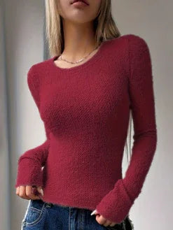 woman wearing fitted long sleeve fuzzy red sweater with thumb holes and blue jeans