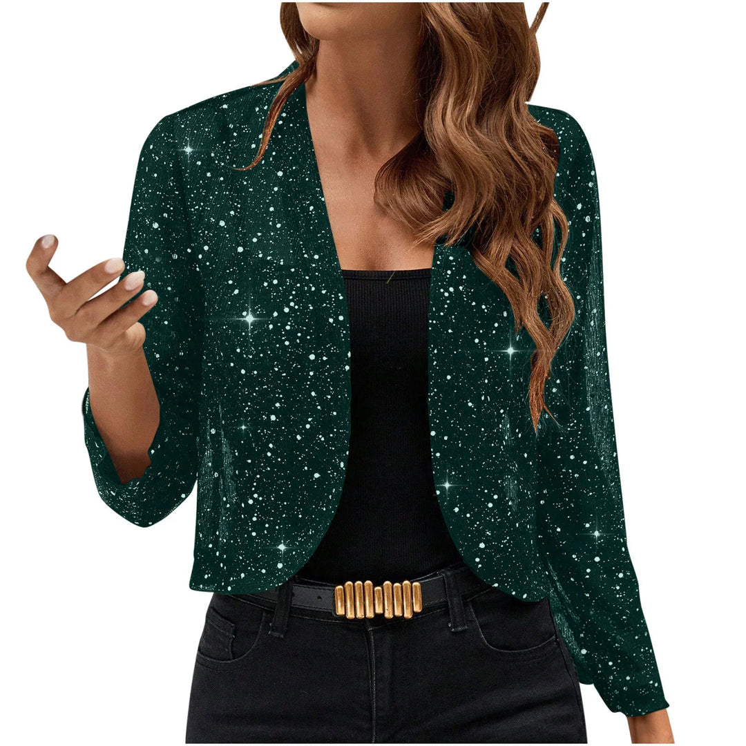 Woman wearing a dark green starry sparkle cardigan over a black top with black pants and gold belt buckle