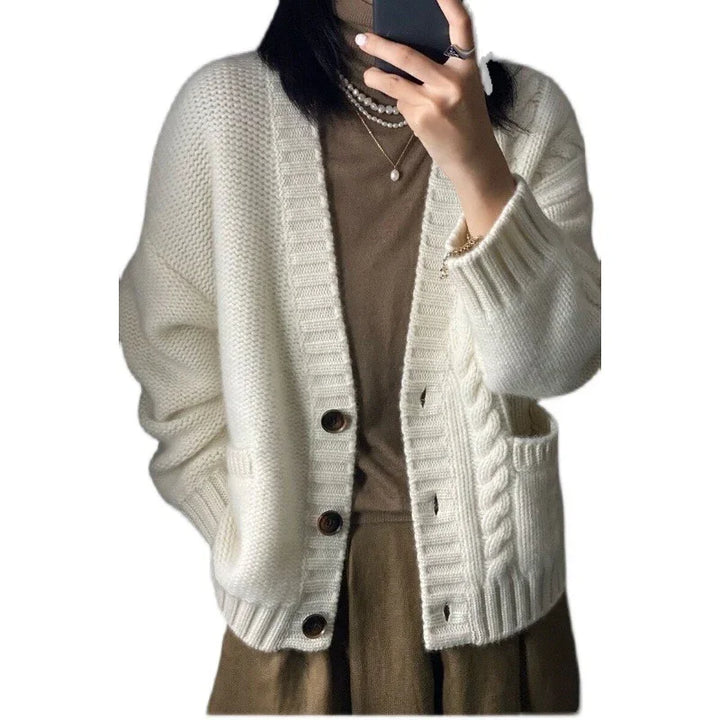 Woman wearing cozy cream knit cardigan over brown turtleneck and skirt, accessorized with pearl necklaces