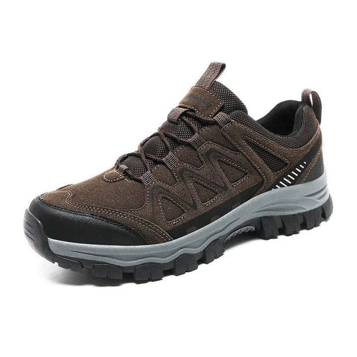 Brown and black hiking shoe with rugged sole and lace-up design on white background