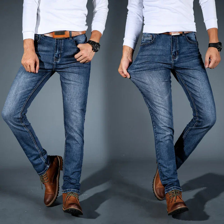 Man wearing blue stretch slim fit jeans with brown leather belt and boots, demonstrating fabric elasticity