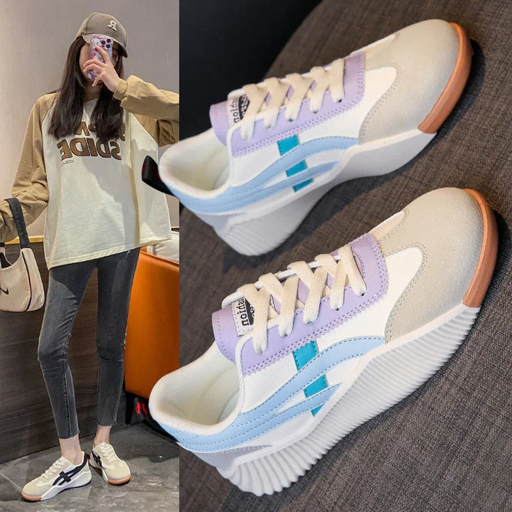 Casual white sneakers with pastel purple, blue accents and gum soles, worn with casual outfit