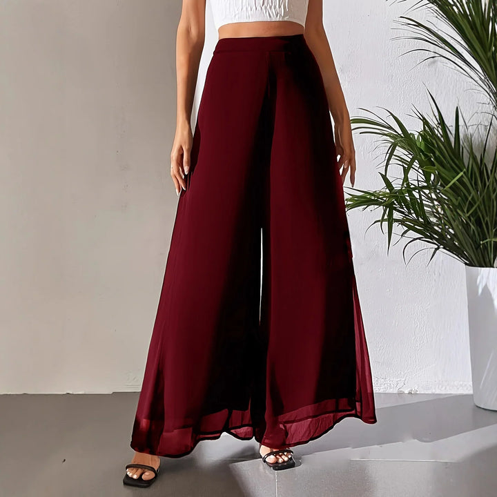 Woman wearing high-waisted wide-leg burgundy palazzo pants with black strappy sandals