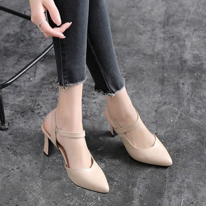 Woman wearing beige pointed-toe slingback heels with ankle strap and black frayed hem jeans on gray floor