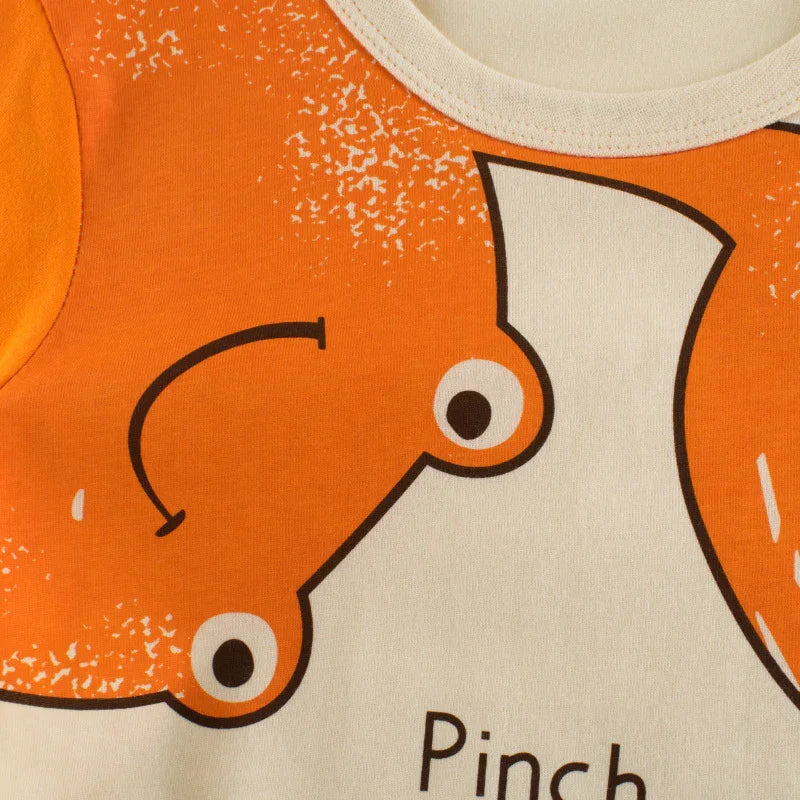 Close-up of orange crab graphic on beige fabric with text 'Pinch' in children's clothing