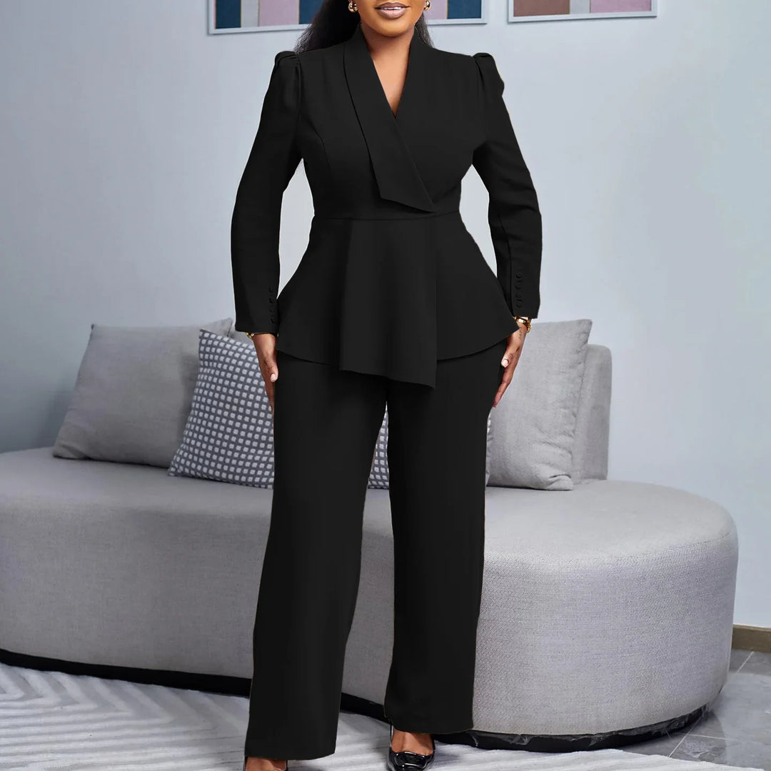 Woman wearing elegant black peplum blazer and wide-leg pants standing in modern living room