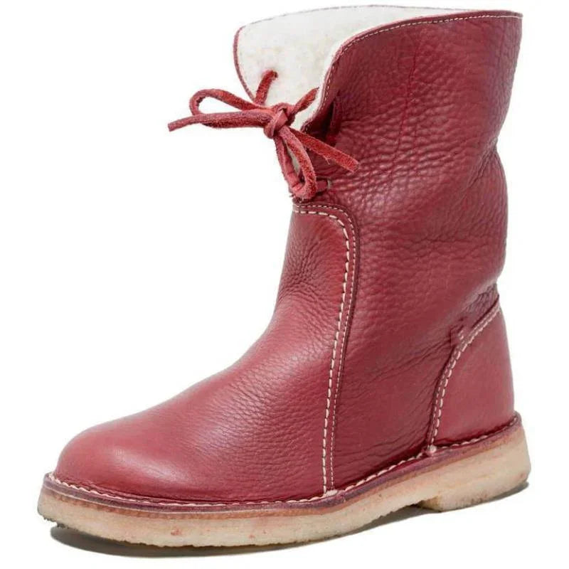 Red leather ankle boot with white stitching, fold-over top, and a flat beige sole