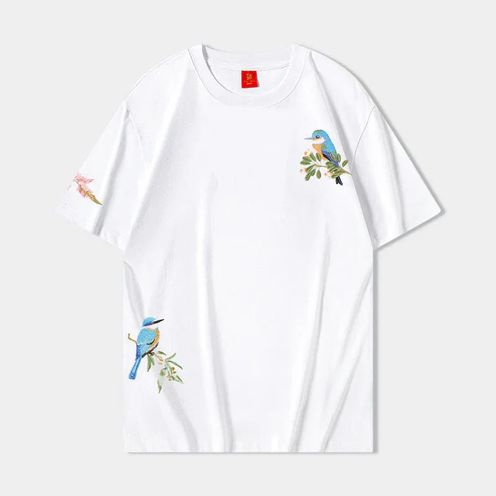 White t-shirt with blue bird embroidery on chest, sleeve, and lower side, nature-inspired design