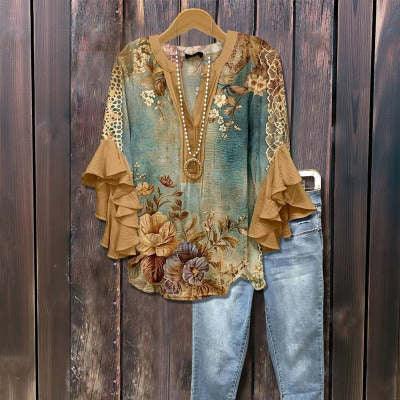 Boho floral blouse with ruffled bell sleeves and blue jeans displayed on wooden background
