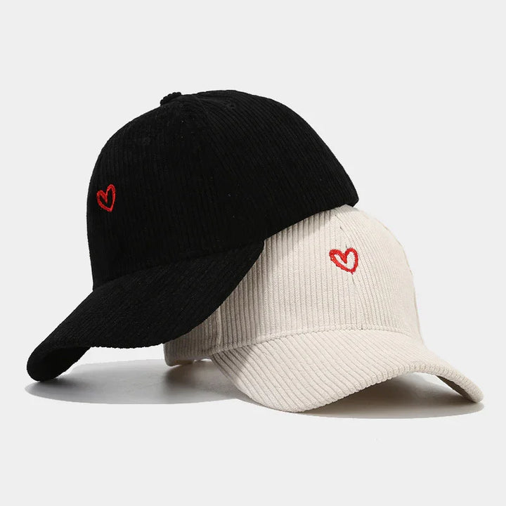 Black and white ribbed baseball caps with small red embroidered heart on front, stylish casual hats