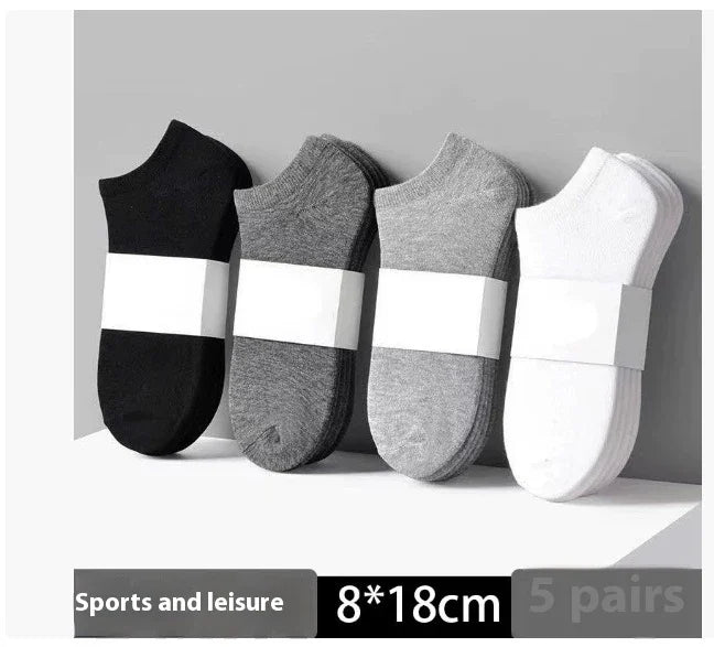 Set of four pairs of ankle sports socks in black, dark gray, light gray, and white with packaging bands