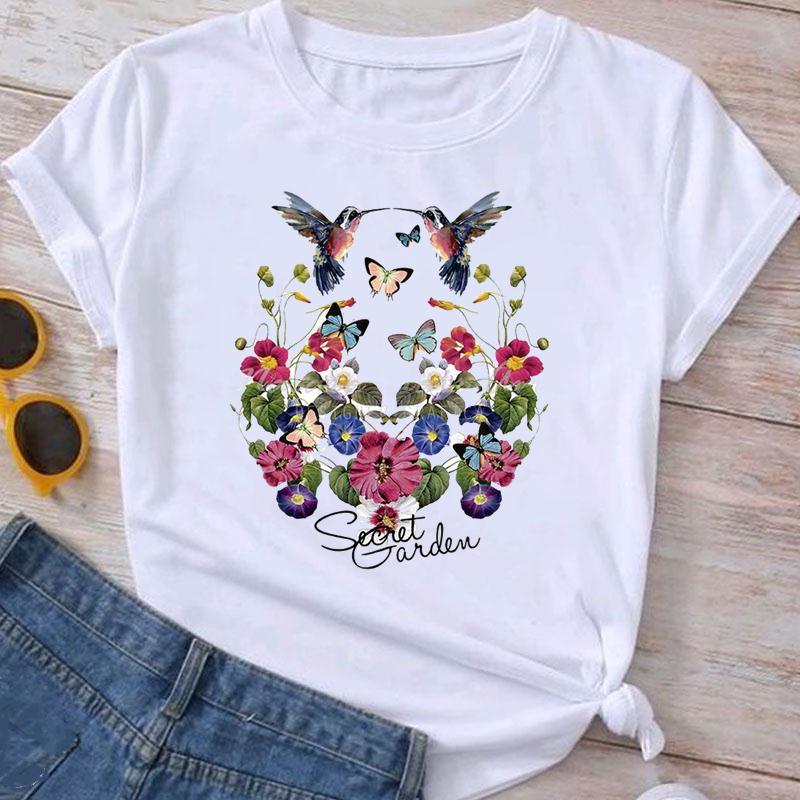 White T-shirt with colorful hummingbirds, butterflies, and vibrant floral design, text Secret Garden