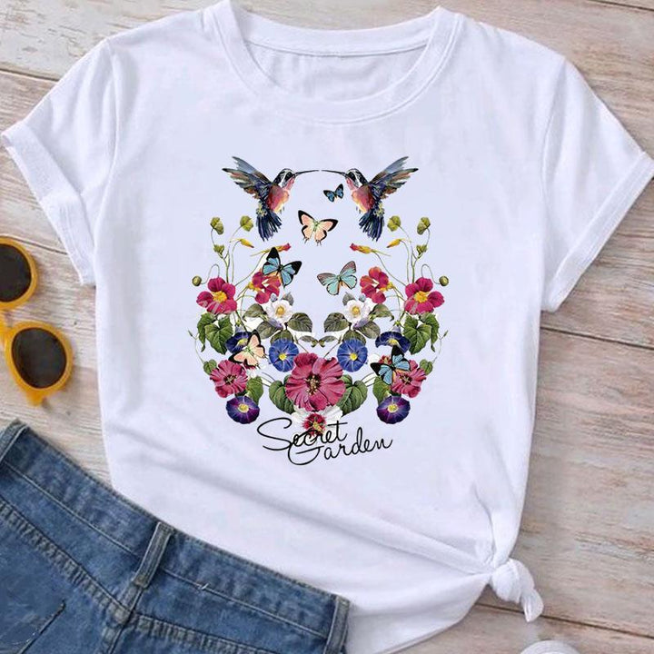 White T-shirt with colorful hummingbirds, butterflies, and vibrant floral design, text Secret Garden