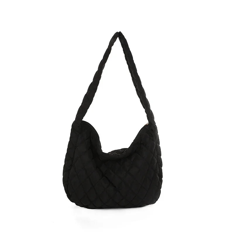 Black quilted shoulder bag with a textured padded design and a single strap on white background