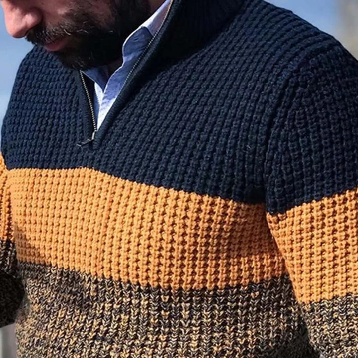 Close-up of man wearing a textured knit sweater with navy, orange, and brown stripes