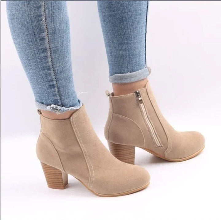Beige suede ankle boots with side zipper and block heels worn with rolled-up blue skinny jeans