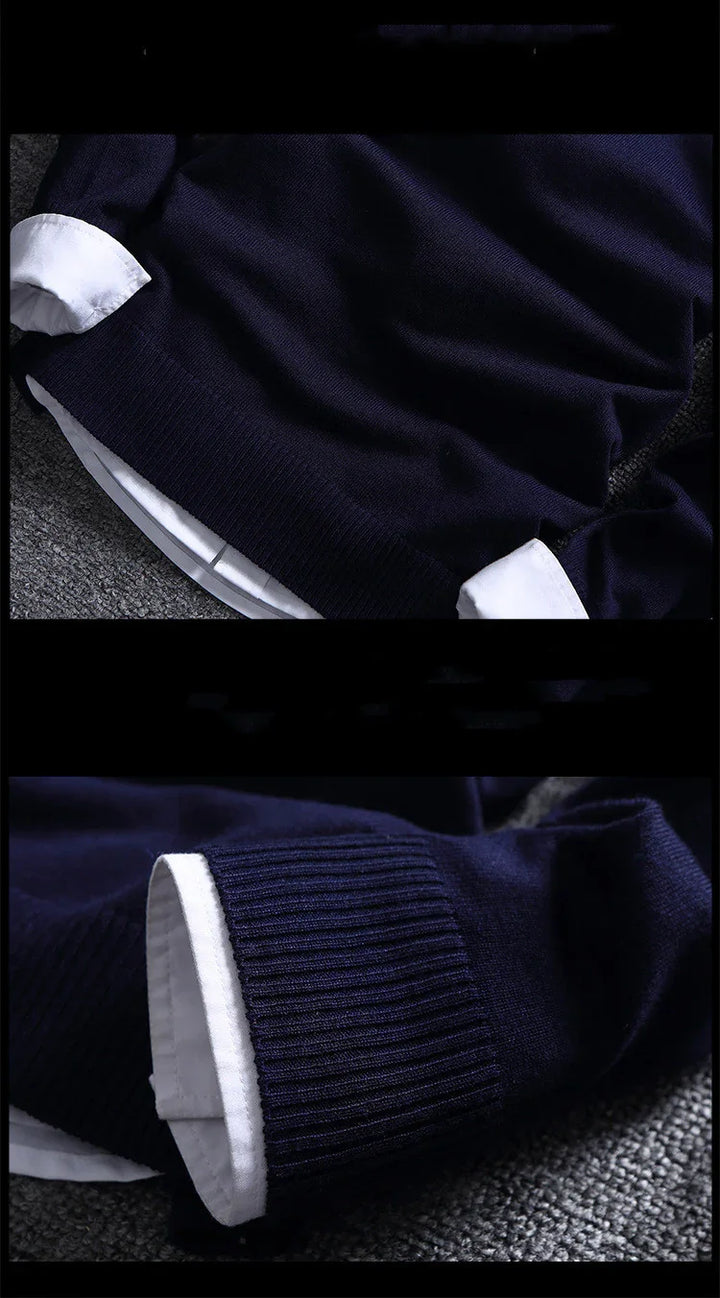 Close-up of navy blue sweater with white shirt cuffs and hem on gray textured surface
