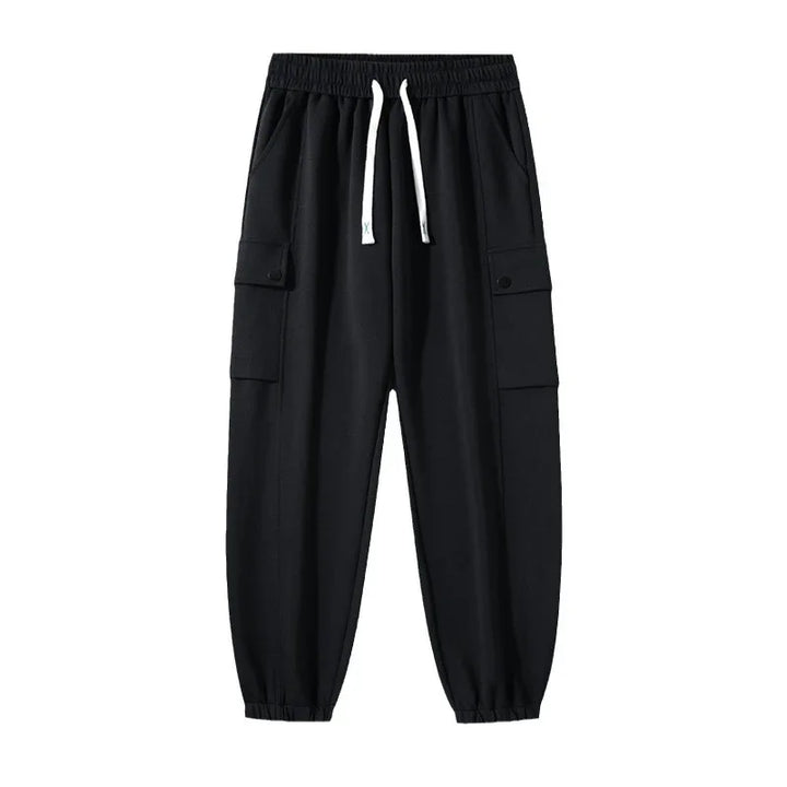 Black cargo jogger pants with elastic waistband and white drawstrings isolated on white