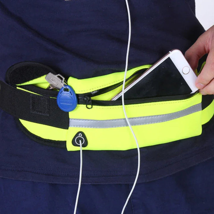 Person wearing a neon yellow reflective running belt with keys and smartphone, using earphones