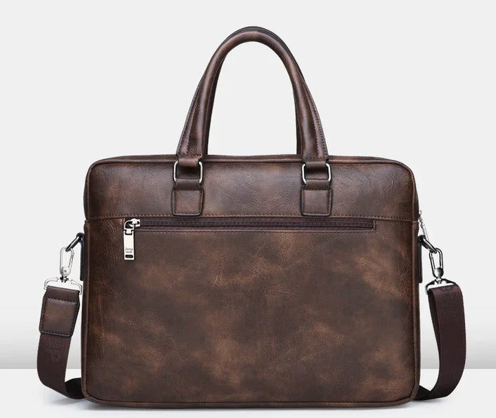 brown vintage leather briefcase with handles and detachable shoulder strap against white background