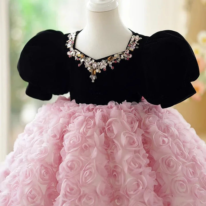 Elegant baby dress with black velvet puff sleeves and pink rose-textured skirt, adorned neckline