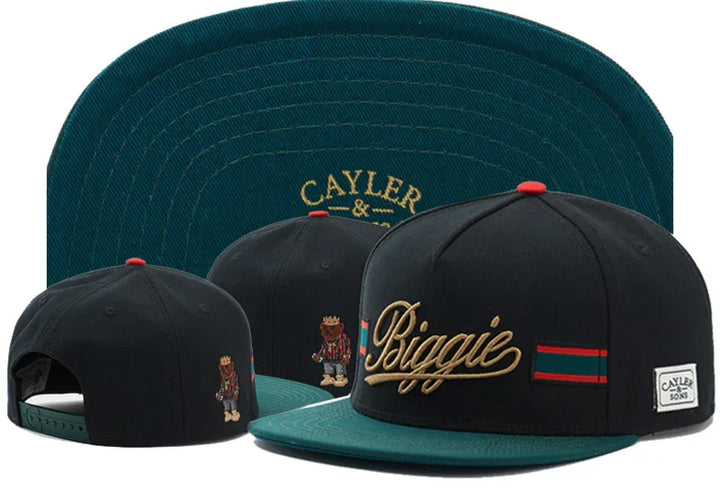 Black and green snapback hat with gold Biggie embroidery, bear logo, and Cayler & Sons branding