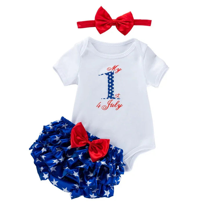Baby's first 4th of July outfit with white onesie, blue star ruffle shorts, and red bow headband