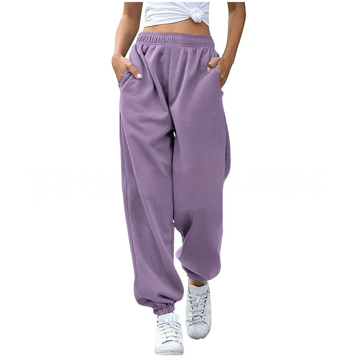 Woman wearing high-waisted lavender purple jogger sweatpants with elastic cuffs and pockets