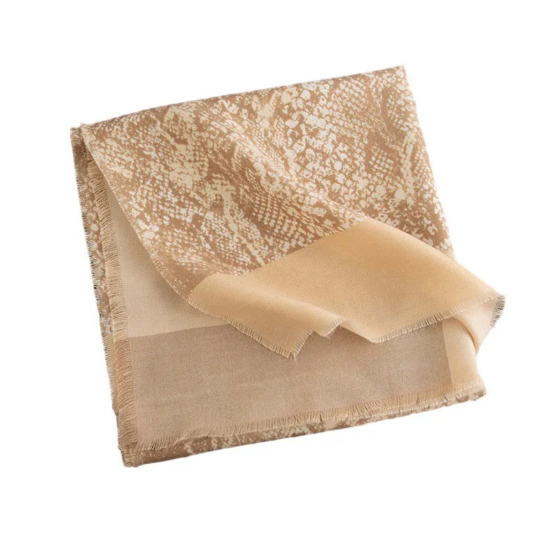 Beige and tan folded scarf with snake print pattern and fringe edges on white background