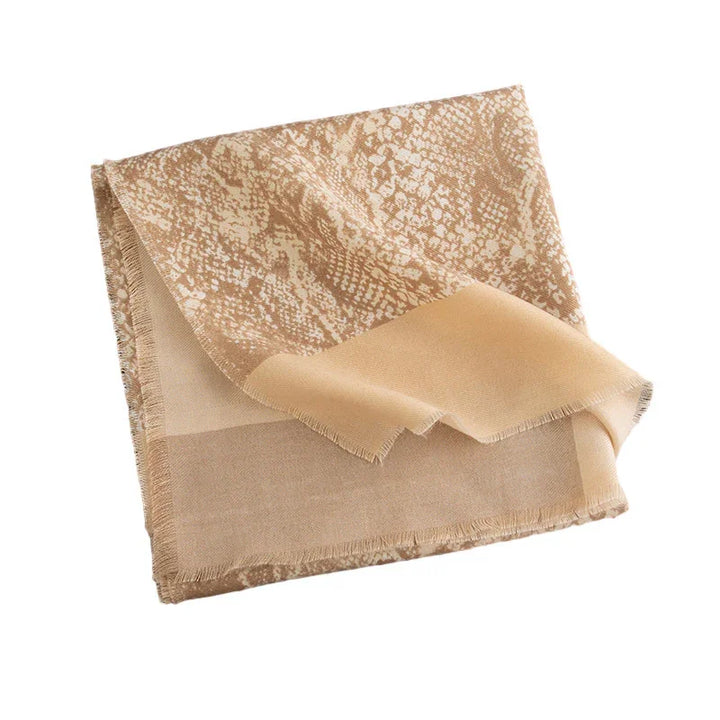 Beige and tan folded scarf with snake print pattern and fringe edges on white background