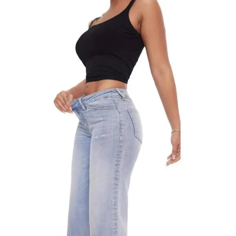 Woman in black tank top showing loose light blue jeans for weight loss