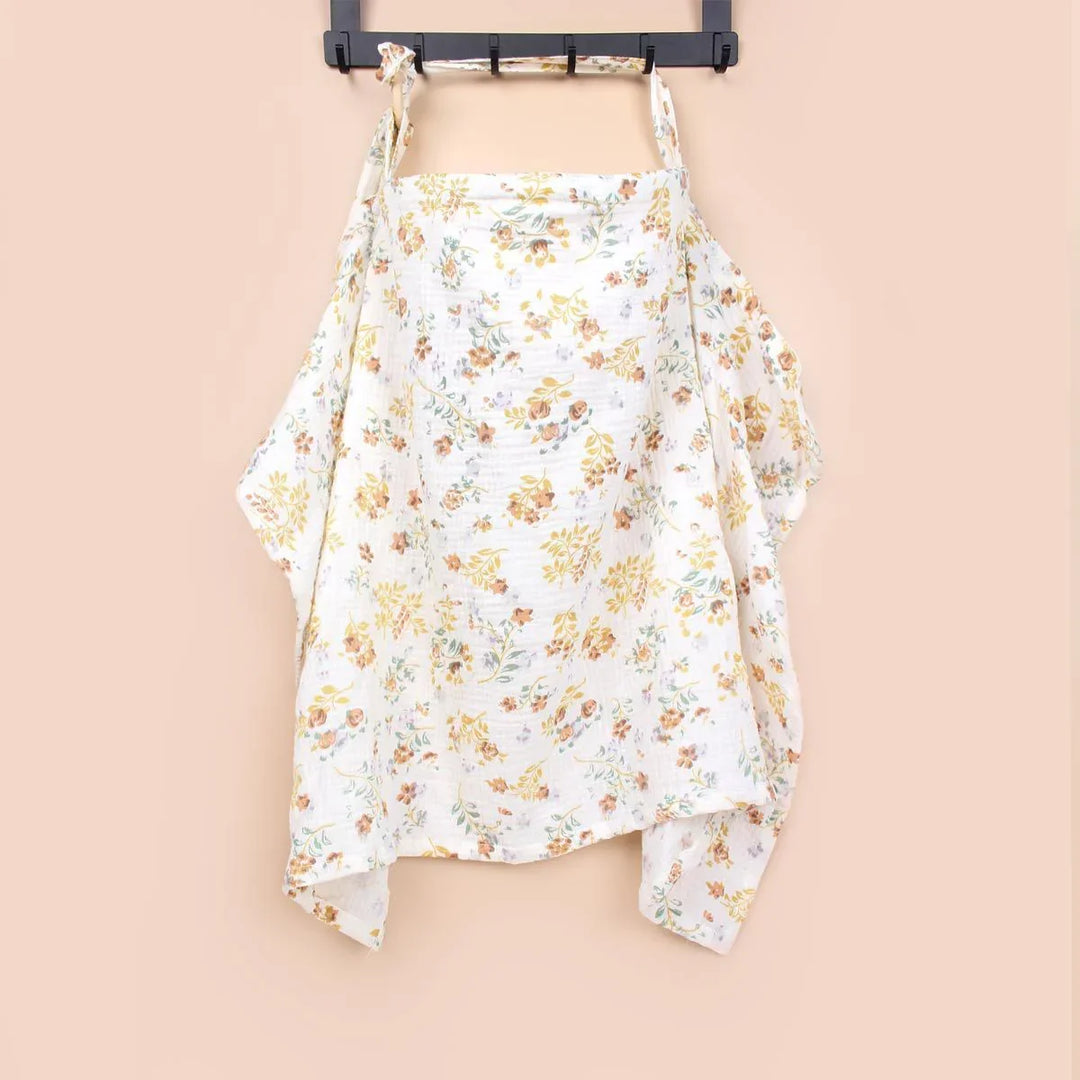 White floral nursing cover with yellow and brown flowers hanging on black hanger against beige background