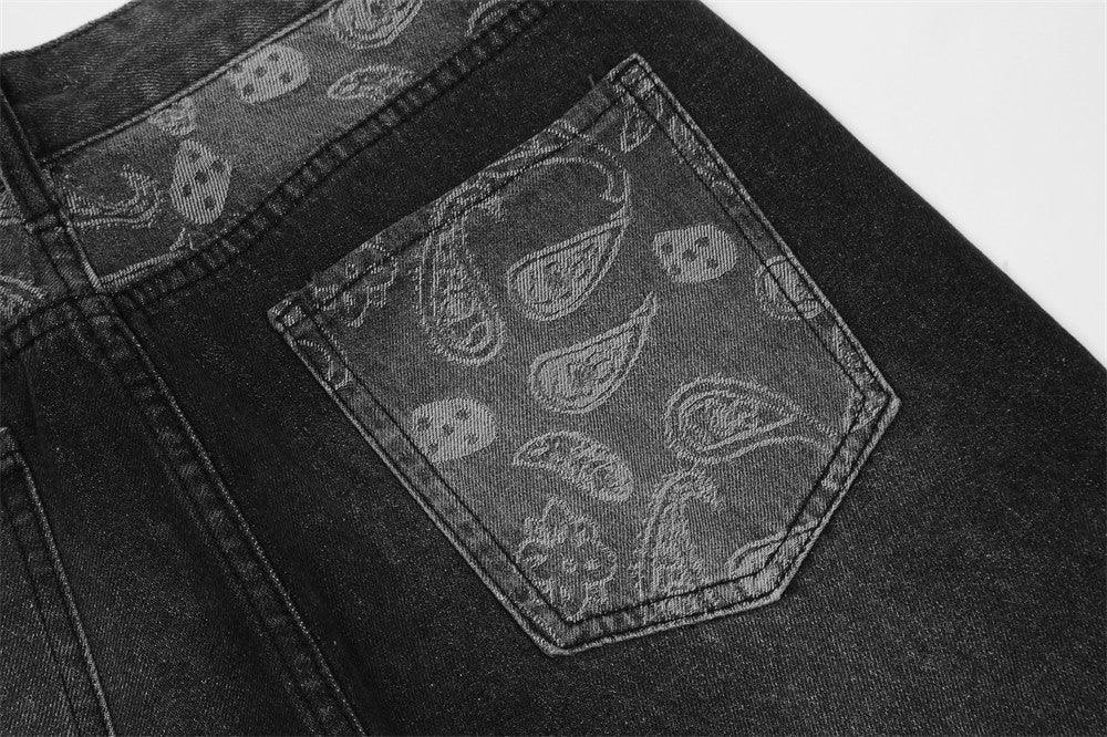 Close-up of black denim jeans with paisley patterned back pocket and waistband