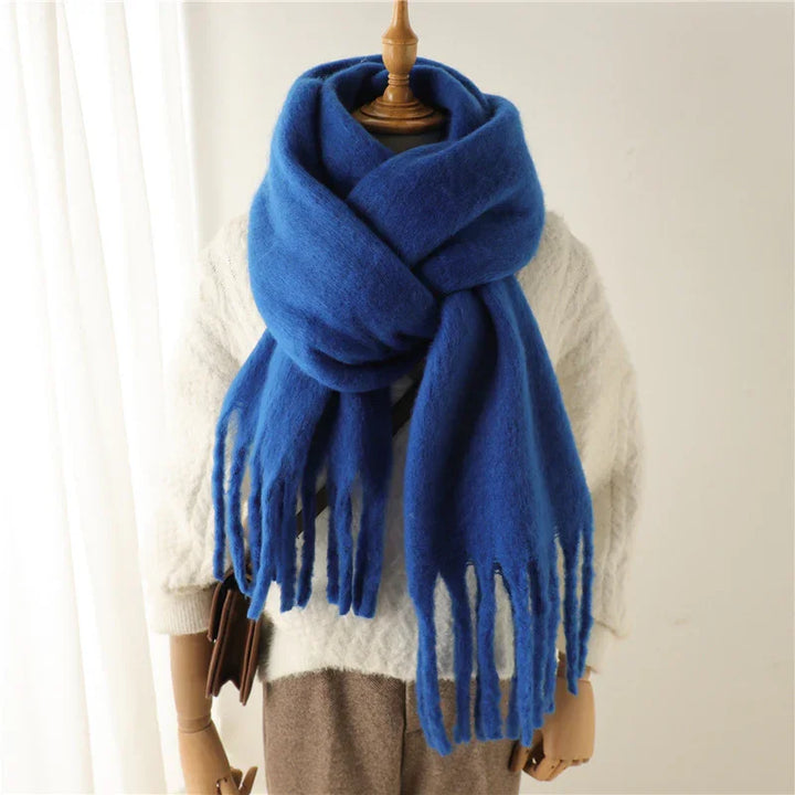 Cozy blue fringed wool scarf on mannequin wearing white cable knit sweater and brown pants