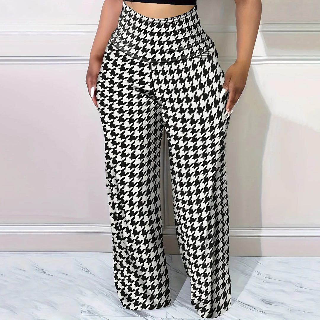 Woman wearing black and white houndstooth wide-leg pants with high waist against white wall