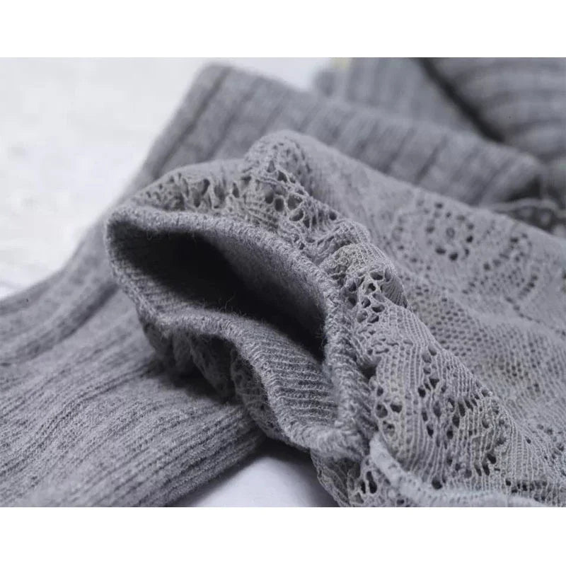 Close-up of soft gray ribbed and lace knit fabric, highlighting intricate patterns and texture