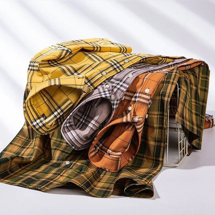 Stack of folded plaid button-up shirts in yellow, gray, orange, and green on white background
