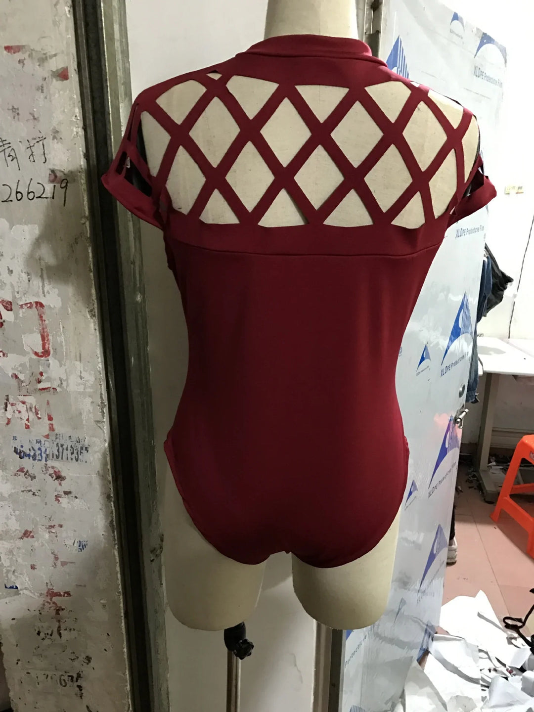 Back view of burgundy bodysuit with lattice cutout design on upper back displayed on mannequin