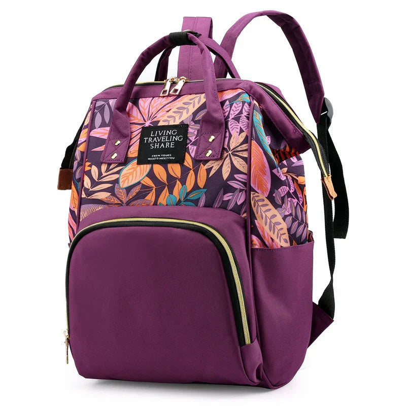 Purple backpack with colorful leaf pattern, front zipper pocket, and dual handles for travel and daily use