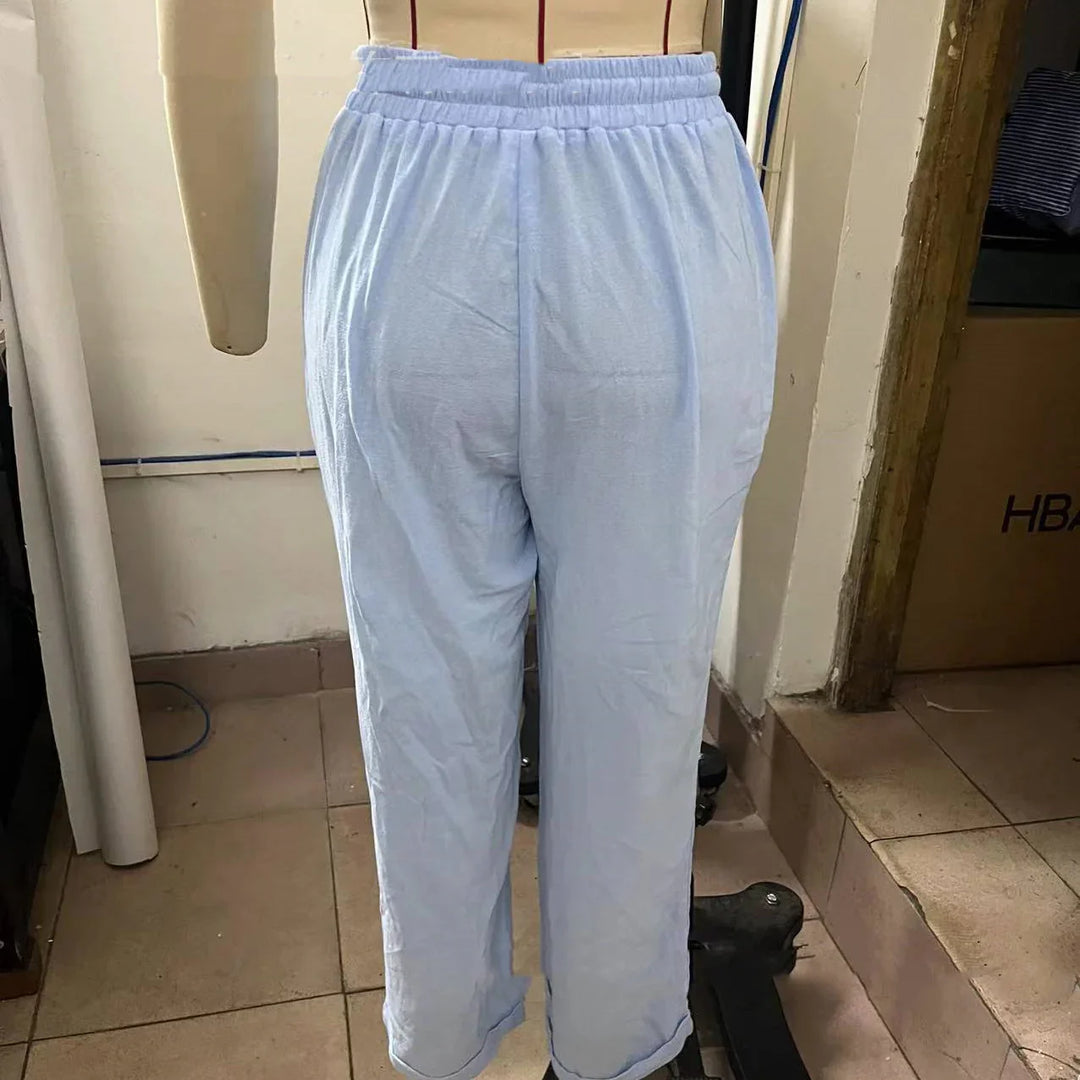 Light blue cotton pants with elastic waistband displayed on a mannequin in a room