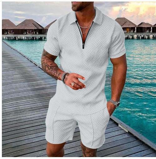 man wearing white textured short-sleeve zip polo shirt and matching shorts on wooden pier by water villas