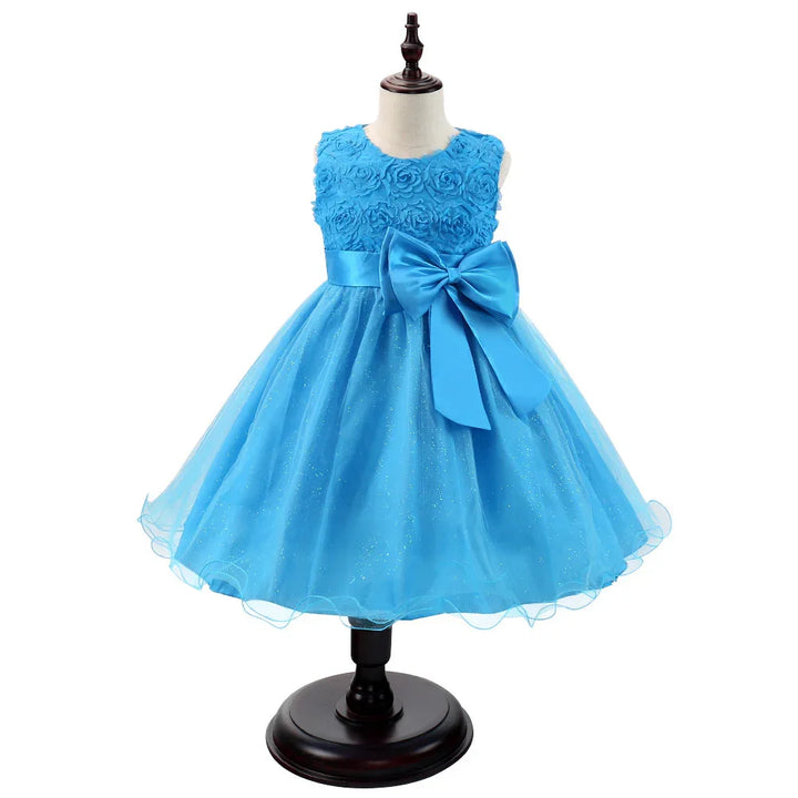 Blue sleeveless flower embellishment girls party dress with a large satin bow on mannequin