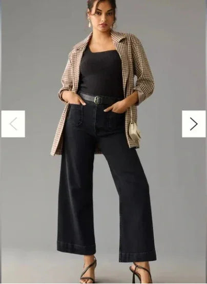 Fashion model wearing black wide-leg pants, black tank top, tan checkered jacket, and black heels