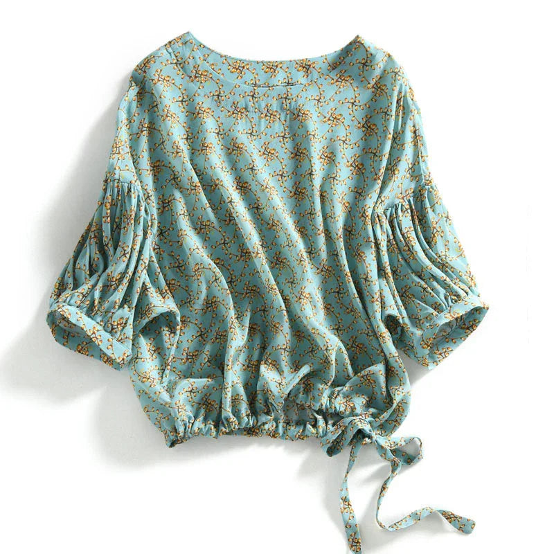 Blue floral print blouse with puffed sleeves and adjustable tie waist detail