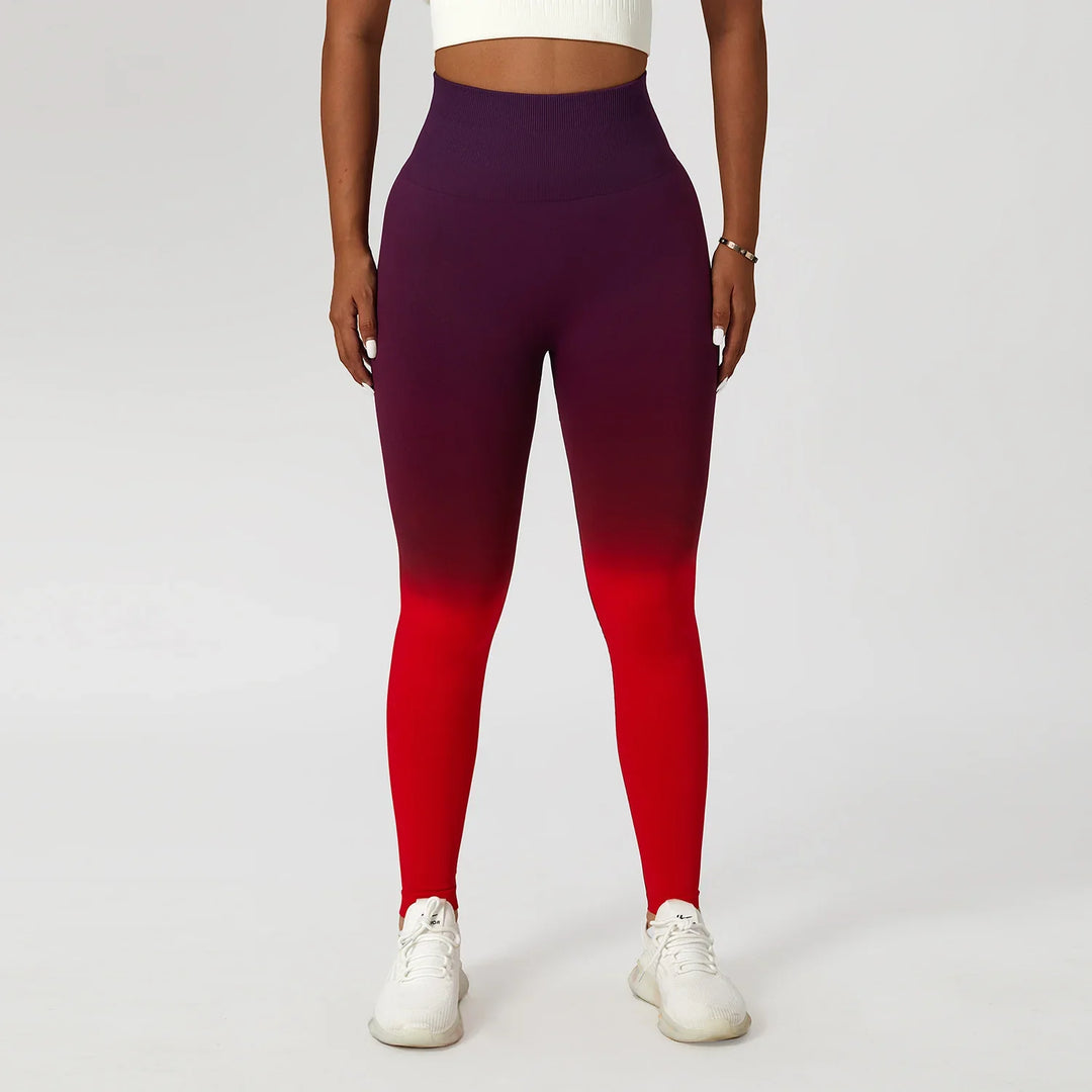 Woman wearing high waisted ombre purple to red seamless leggings and white sneakers