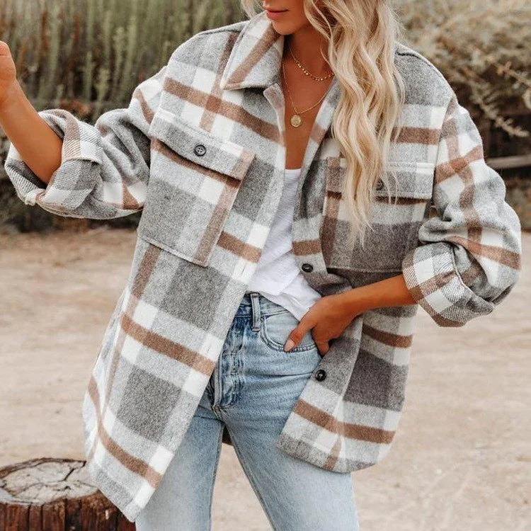 Woman in oversized gray, white, and brown plaid shacket paired with light blue jeans outdoors