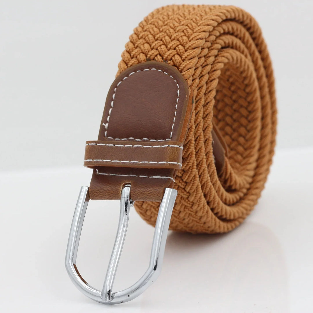 Tan woven fabric belt with brown leather end and silver buckle on white background