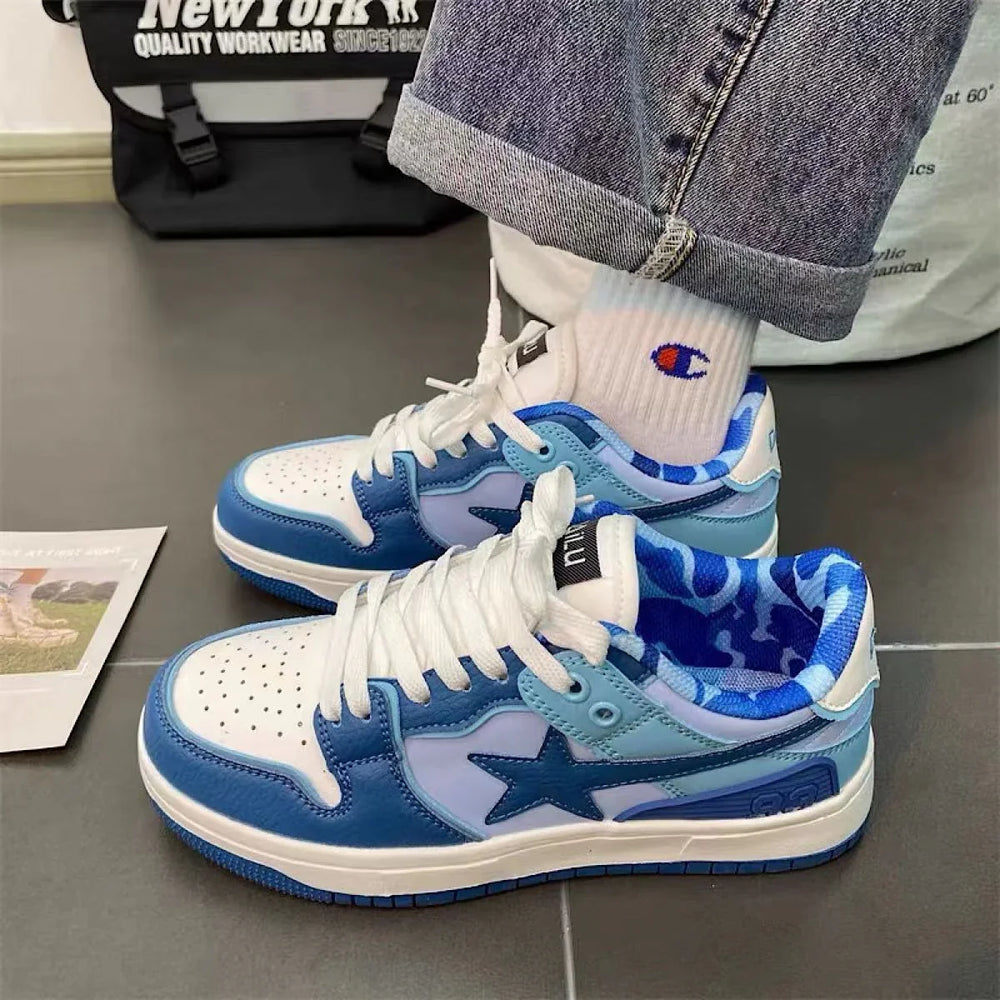 Blue and white low-top sneakers with star logo, worn with white Champion socks and cuffed jeans