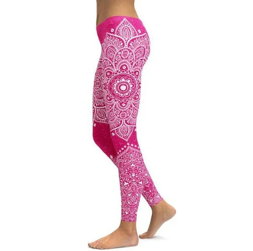 Woman wearing pink yoga leggings with white intricate mandala pattern, standing barefoot on white background