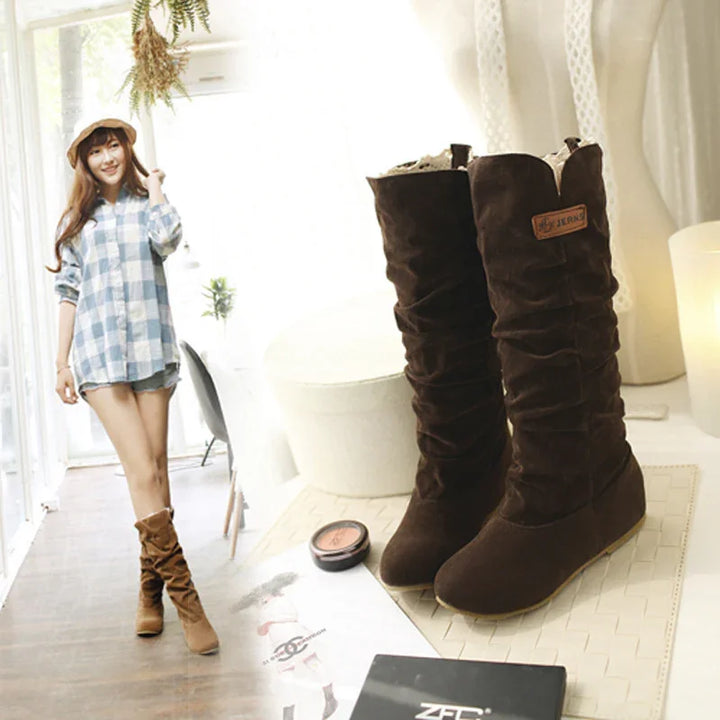 Brown suede slouchy mid-calf boots with zipper, styled on woman wearing casual outfit indoors